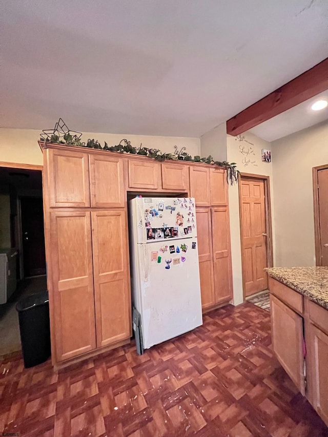 kitchen featuring light brown cabinets, dark parquet flooring, light stone countertops, and white refrigerator