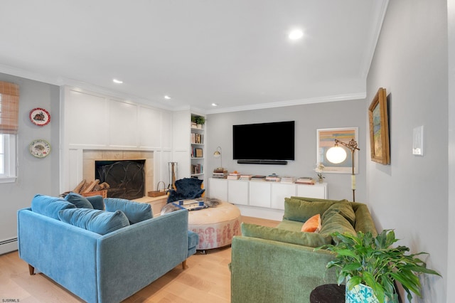 living room with ornamental molding, a fireplace, and light hardwood / wood-style flooring