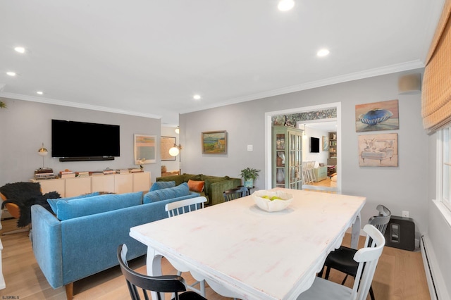 dining area with crown molding, a baseboard heating unit, and light hardwood / wood-style floors