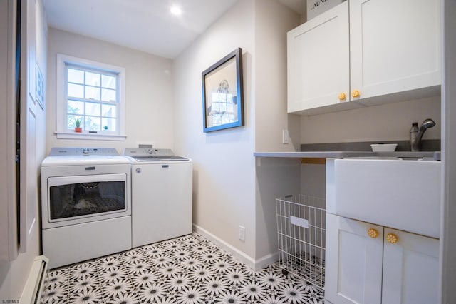 clothes washing area with independent washer and dryer, a baseboard radiator, and cabinets