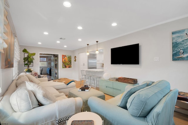 living room with crown molding and light hardwood / wood-style flooring