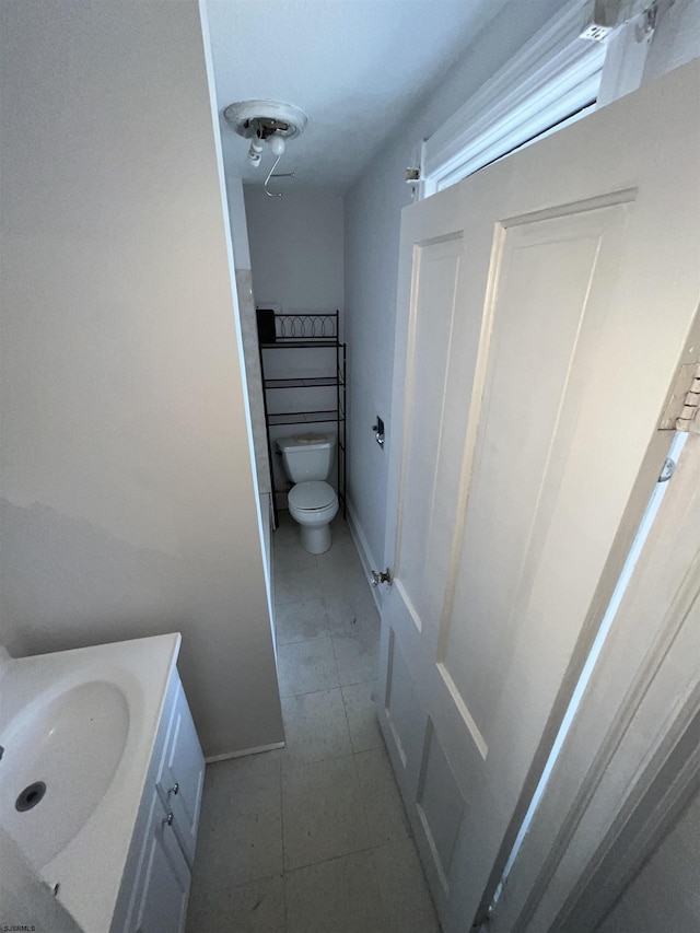 bathroom featuring vanity, tile patterned flooring, and toilet