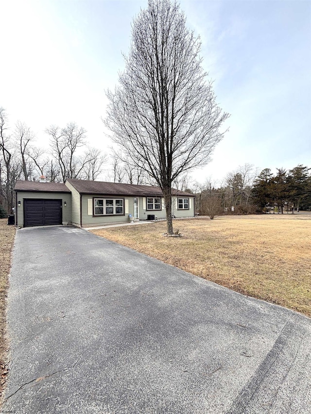 single story home featuring a garage and a front yard