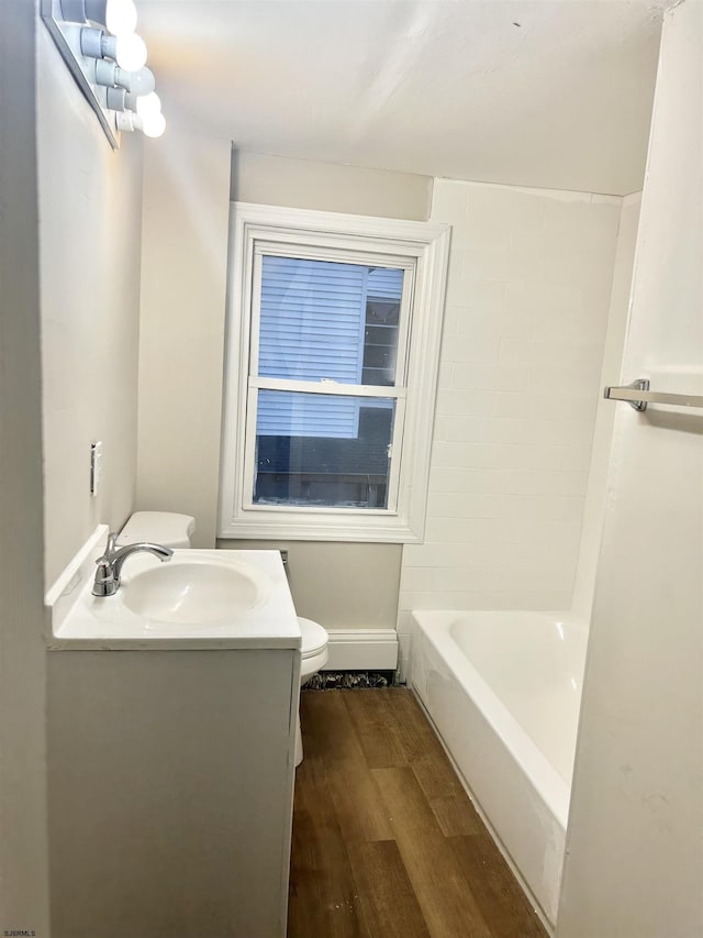 bathroom featuring vanity, a bathtub, wood-type flooring, and toilet