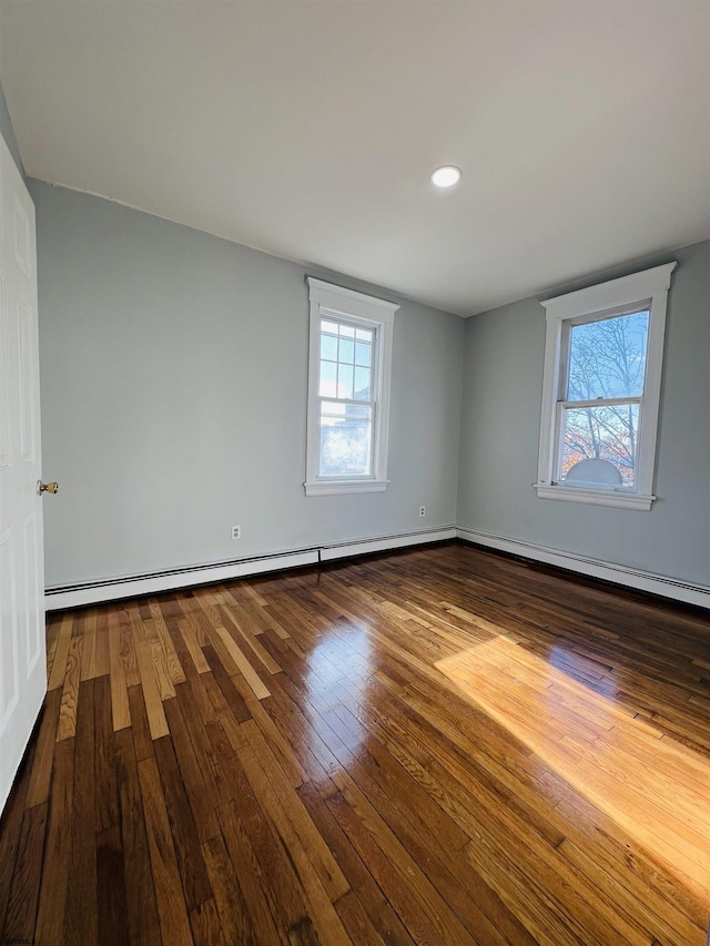 spare room with hardwood / wood-style floors and baseboard heating