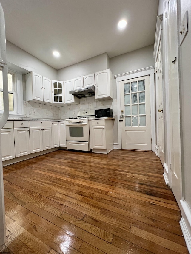 kitchen featuring tasteful backsplash, dark hardwood / wood-style floors, white cabinets, and gas range gas stove