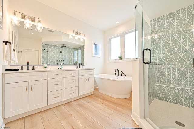 bathroom with vanity, hardwood / wood-style floors, and shower with separate bathtub