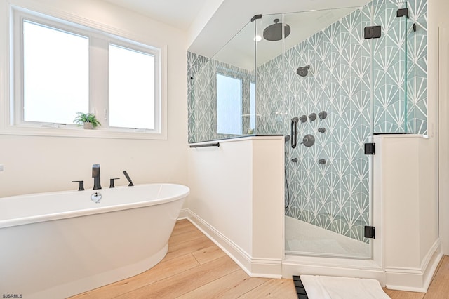 bathroom with hardwood / wood-style floors and independent shower and bath