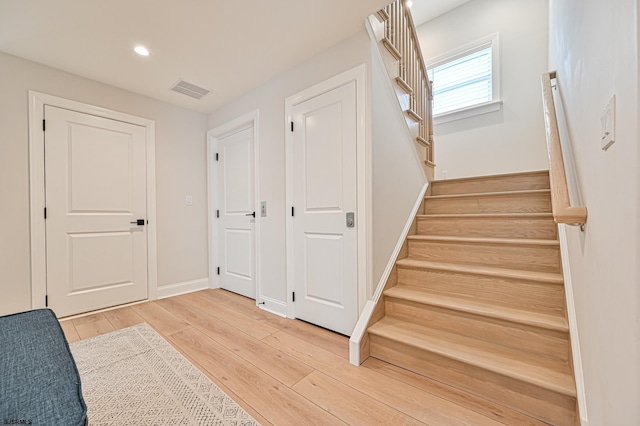 staircase with hardwood / wood-style floors