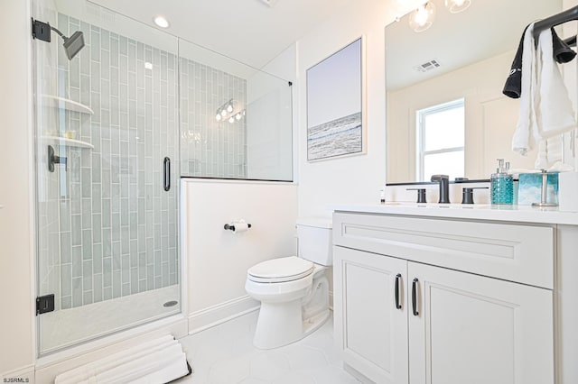 bathroom featuring vanity, a shower with shower door, and toilet