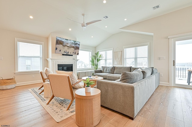 living room with ceiling fan, lofted ceiling, and light wood-type flooring