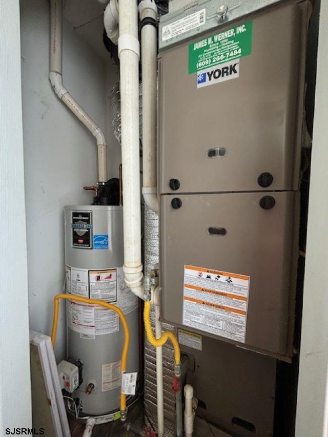 utility room with water heater and heating unit