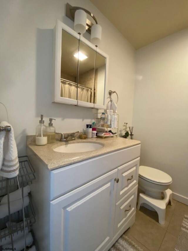 bathroom with vanity, tile patterned floors, and toilet