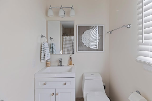 bathroom featuring vanity, walk in shower, and toilet