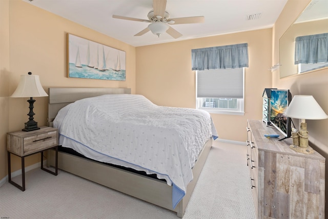 carpeted bedroom with ceiling fan, visible vents, and baseboards