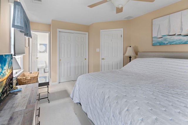 bedroom featuring light carpet, connected bathroom, a closet, and ceiling fan