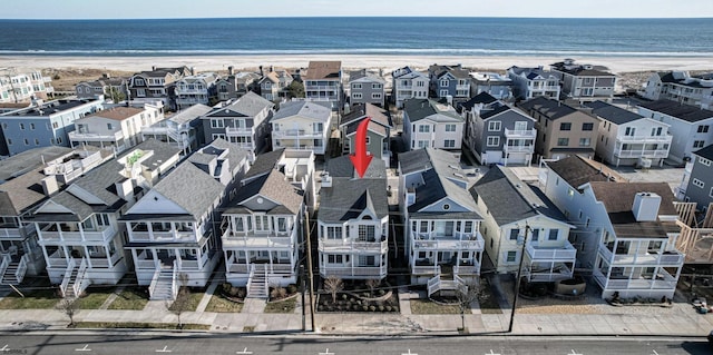 birds eye view of property featuring a water view, a residential view, and a beach view