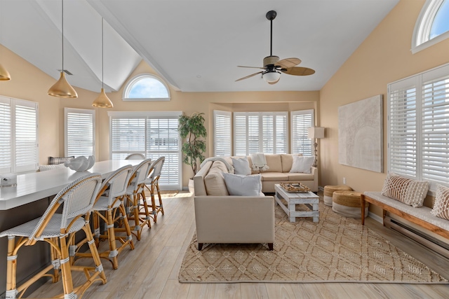 living room with ceiling fan, high vaulted ceiling, and light wood-type flooring