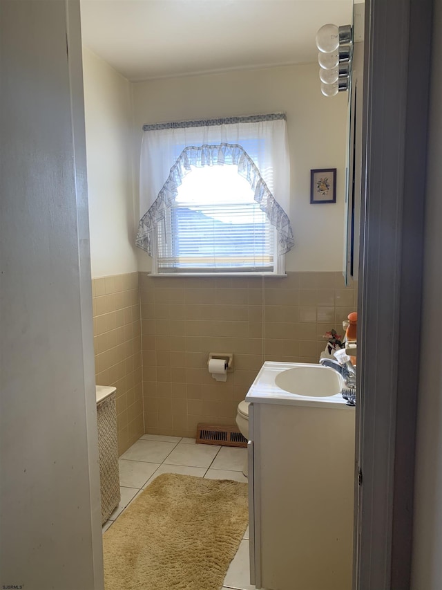 bathroom with vanity, toilet, tile patterned flooring, and tile walls