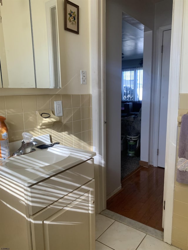 bathroom with sink, tile patterned flooring, and backsplash