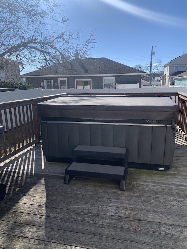 wooden deck featuring a hot tub