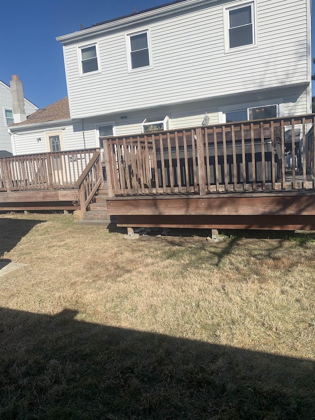 rear view of property with a yard and a deck