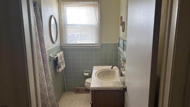 bathroom with tile patterned floors, toilet, tile walls, and vanity