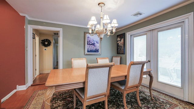 dining room featuring an inviting chandelier, ornamental molding, hardwood / wood-style floors, and french doors