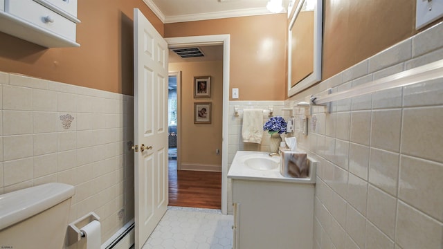 bathroom featuring ornamental molding, vanity, toilet, and tile walls