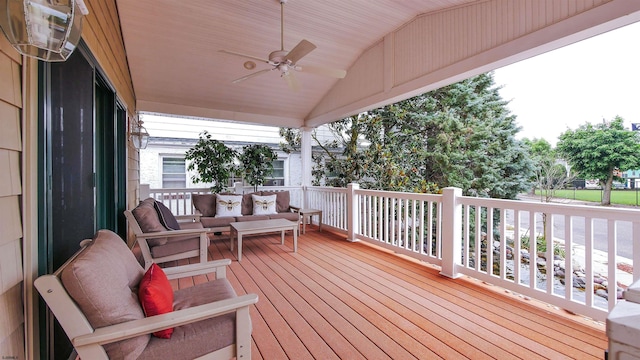 wooden terrace with an outdoor living space and ceiling fan