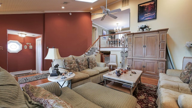 living room with hardwood / wood-style flooring, ornamental molding, an inviting chandelier, and a baseboard heating unit