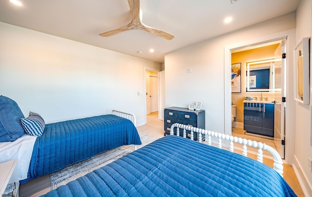 bedroom featuring ceiling fan, connected bathroom, and light hardwood / wood-style floors