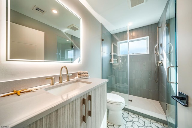 bathroom with vanity, toilet, and a shower with door