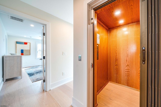 hall featuring elevator, wooden ceiling, and light hardwood / wood-style floors