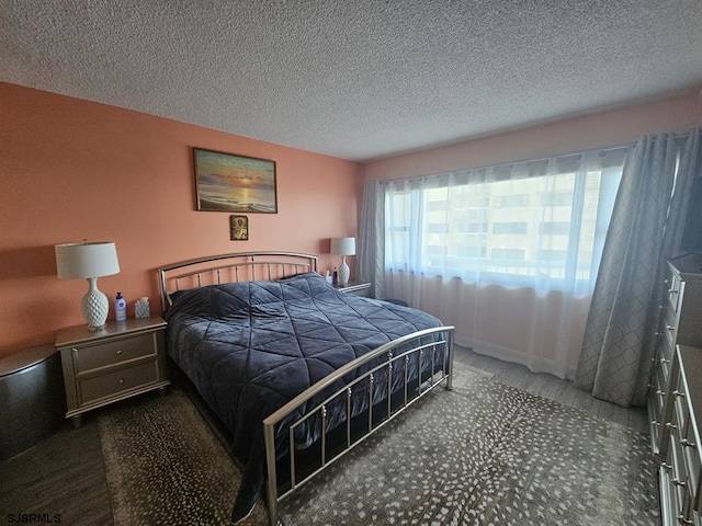 bedroom featuring a textured ceiling and dark colored carpet