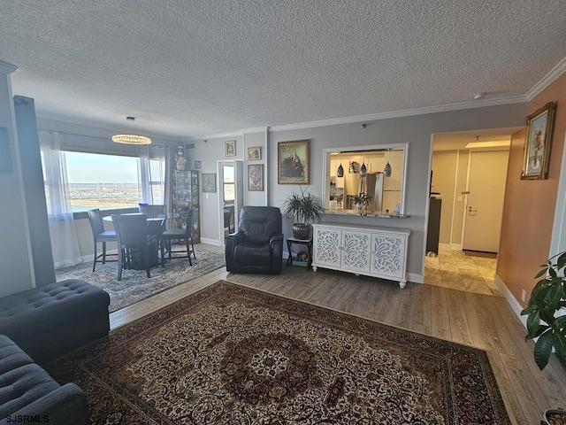 living room featuring ornamental molding, light hardwood / wood-style floors, and a textured ceiling