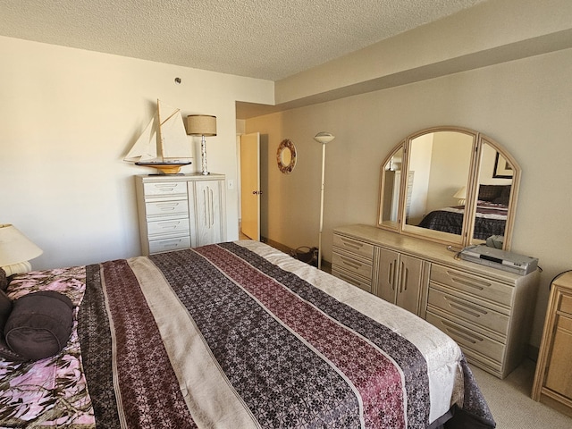 bedroom with light carpet and a textured ceiling