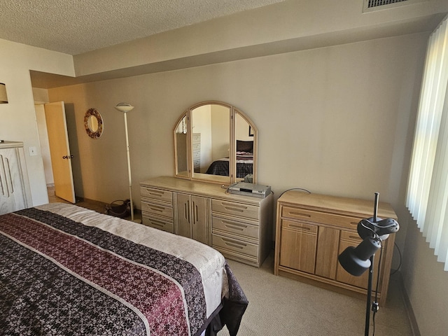 bedroom featuring light colored carpet and a textured ceiling