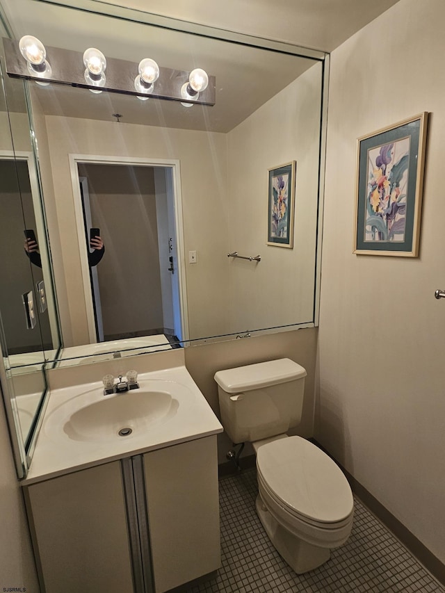 bathroom featuring vanity, tile patterned floors, and toilet