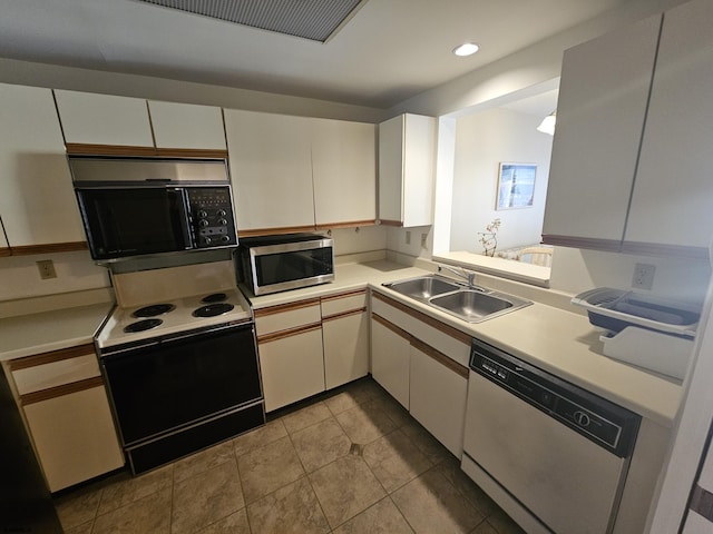 kitchen with white cabinetry, sink, light tile patterned floors, and appliances with stainless steel finishes