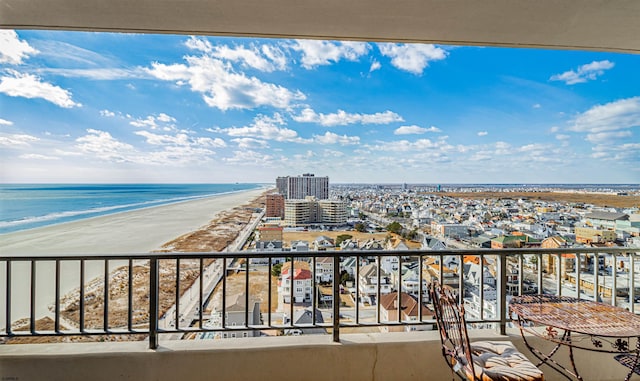 balcony with a water view and a view of the beach