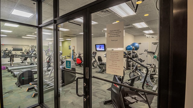 gym featuring a paneled ceiling and carpet