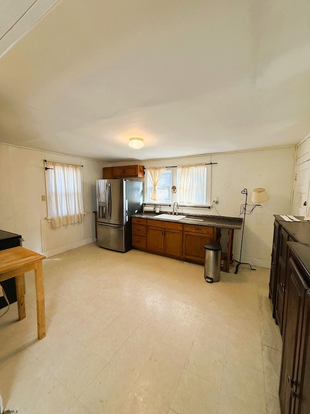 kitchen featuring sink, a kitchen bar, and stainless steel fridge with ice dispenser