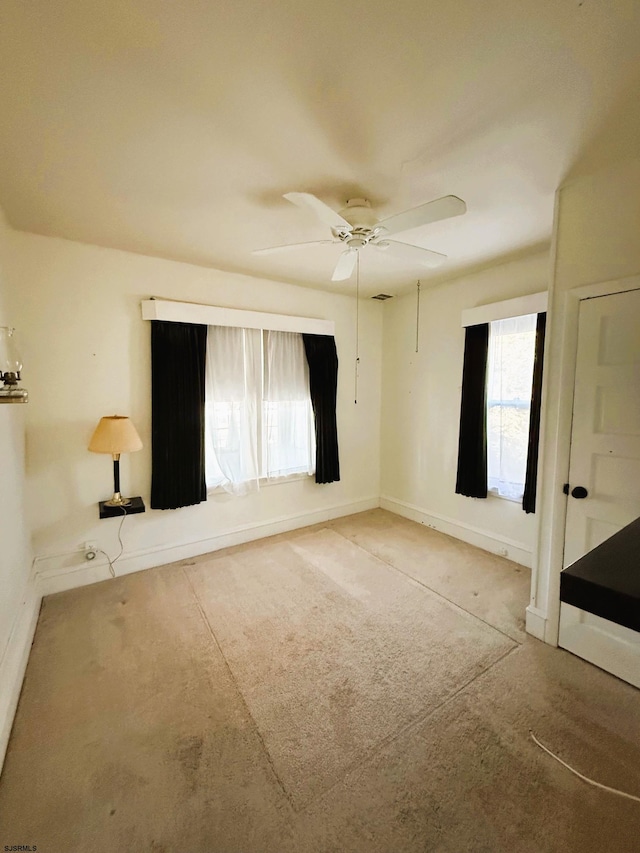 unfurnished bedroom with multiple windows and ceiling fan