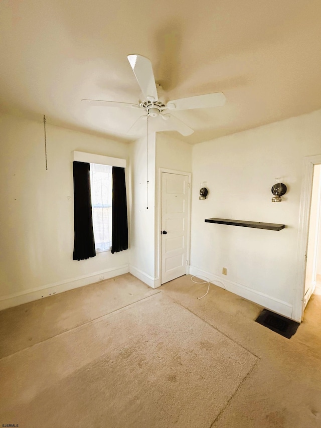 carpeted spare room featuring ceiling fan