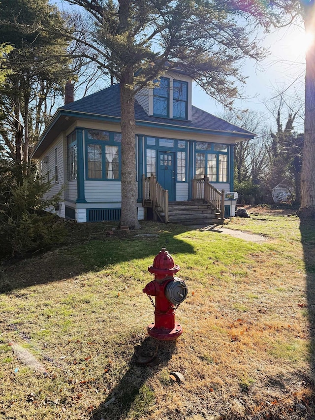 view of front of home with a front lawn and a sunroom