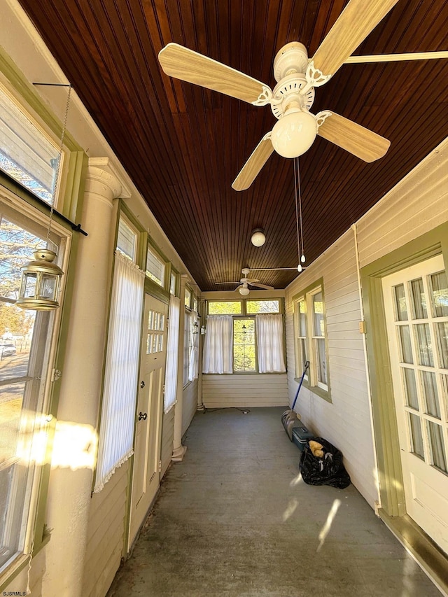 unfurnished sunroom featuring ceiling fan and wooden ceiling