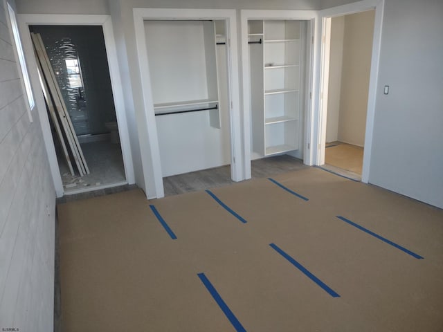 unfurnished bedroom with two closets