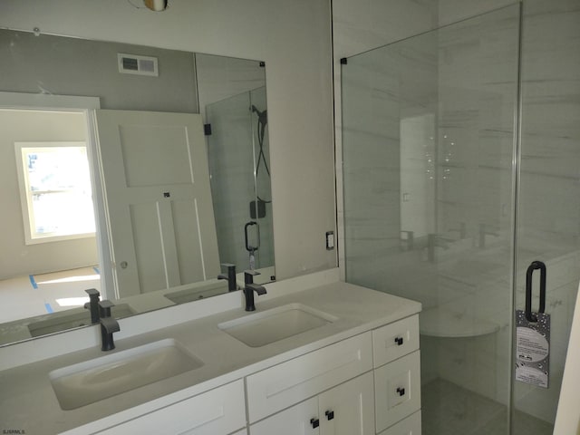 bathroom with vanity and a shower with door