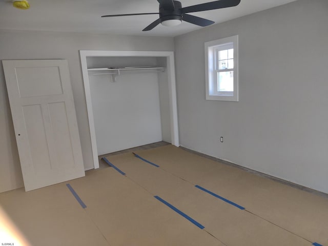 unfurnished bedroom with ceiling fan and a closet